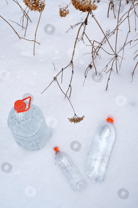 Скачать Бутылки с питьевой водой на снегу. рекламный плакат фотосток Ozero