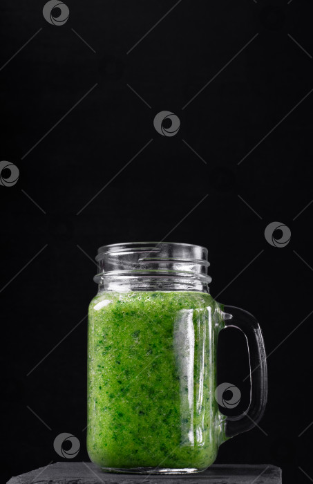 Скачать Зеленый смузи в стеклянной банке на черном фоне. Смешайте капусту, яблоко, грушу, апельсиновый сок и воду. фотосток Ozero