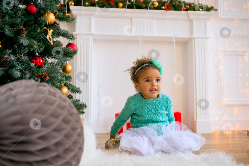 Скачать Happy Mixed Race Toddler Girl under the christmas tree фотосток Ozero