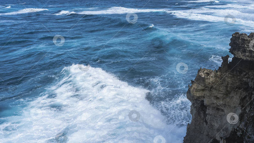 Скачать Волны бушуют в синем океане. Белая пена на поверхности воды. фотосток Ozero