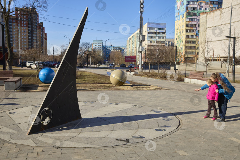 Скачать РАМЕНСКОЕ, Россия - 16 марта 2025 г. - Солнечные часы. Мать объясняет ребенку принцип действия солнечных часов. фотосток Ozero