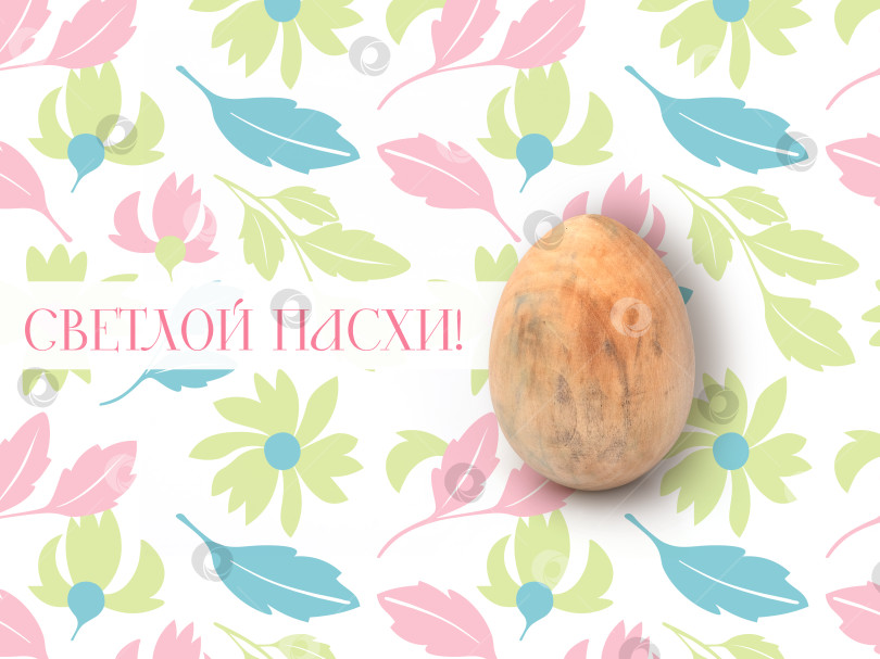 Скачать Деревянное пасхальное яйцо ручной работы для рисования, выделенное на красивом цветочном фоне. Элемент дизайна с контуром вырезки. Надпись на русском языке фотосток Ozero
