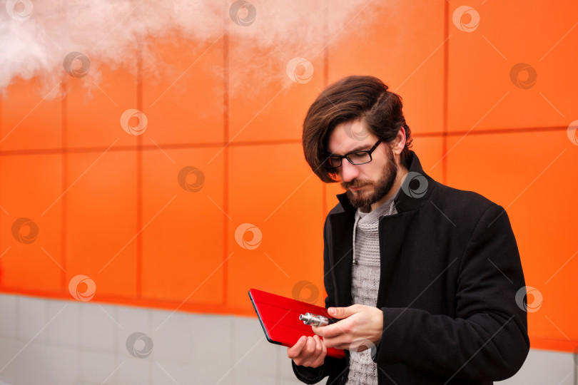 Скачать Мужчина с электронной сигаретой и планшетным ПК. фотосток Ozero