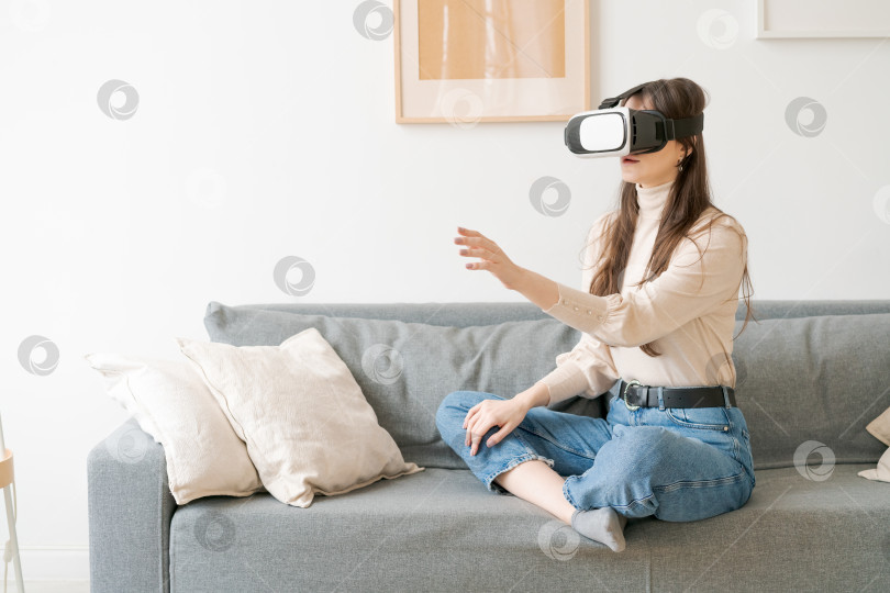 Скачать Женщина сидит на диване и играет в видеоигру фотосток Ozero