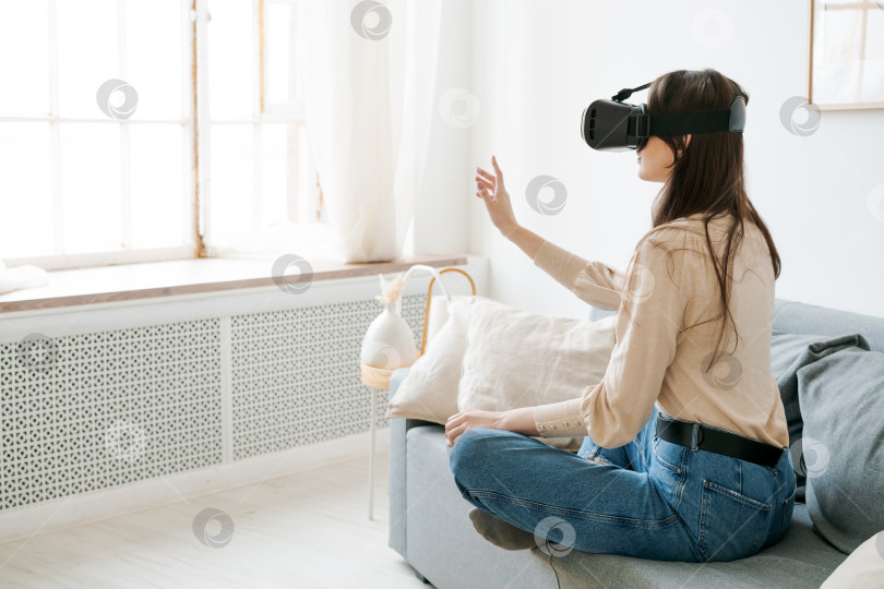 Скачать Женщина сидит на диване и играет в видеоигру фотосток Ozero