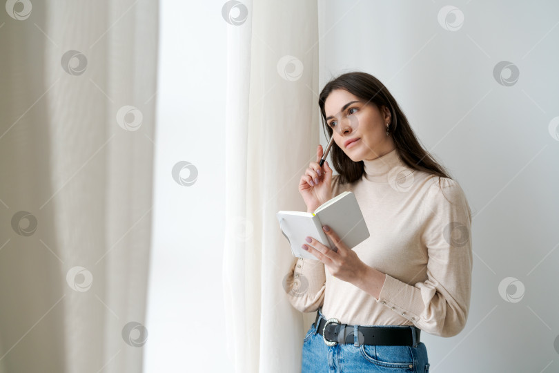 Скачать Женщина смотрит в книгу и что-то пишет в ней фотосток Ozero
