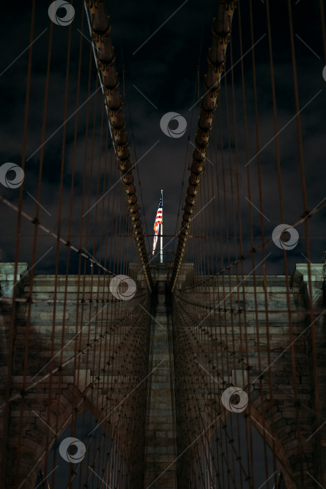 Скачать Бруклинский мост ночью с американским флагом в Нью-Йорке фотосток Ozero