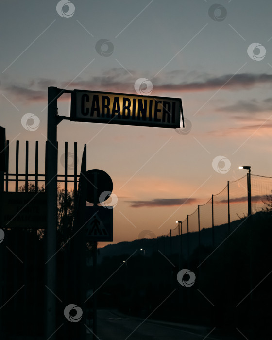 Скачать Знак карабинеров итальянской военной полиции четко вырисовывается на фоне красивого вечернего неба в сумерках. фотосток Ozero