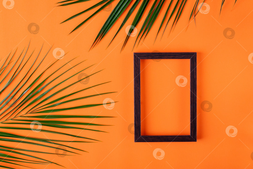 Скачать Оранжевый фон с картинной рамкой и пальмовыми листьями. Шаблон для плоского укладки. фотосток Ozero