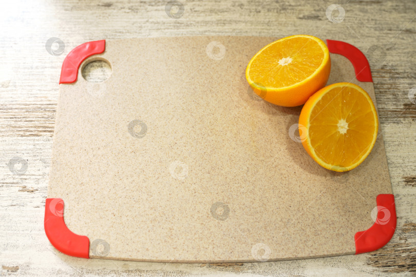 Скачать Разрезанный апельсин лежит на разделочной доске фотосток Ozero