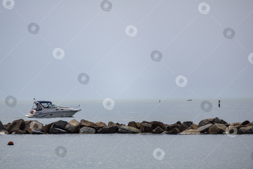 Скачать Катер плывет вдоль берега моря фотосток Ozero