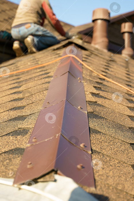 Скачать Мужчина ремонтирует крышу, покрытую черепицей фотосток Ozero