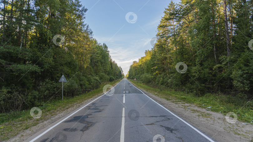 Скачать Асфальтированная дорога в сельской местности, обозначенная на дороге. По краям деревьев и обочинам дорог фотосток Ozero