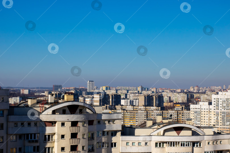 Скачать Яркий городской пейзаж с многочисленными зданиями под ясным голубым небом фотосток Ozero