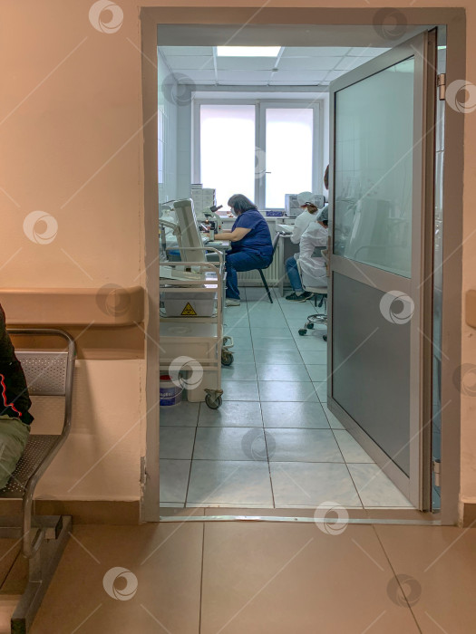 Скачать Вид сбоку на ученого-медика в защитной маске, который использует микроскоп при изучении опасного коронавируса в лаборатории. Вертикальное фото. Россия, Татарстан, 05 апреля 2020 г. фотосток Ozero