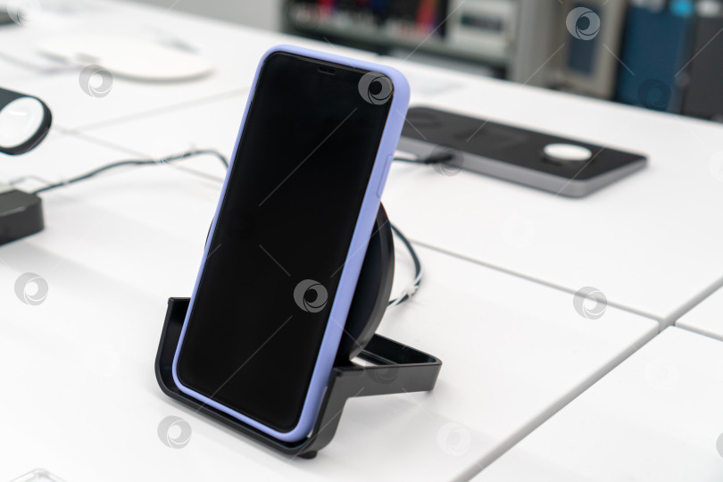 Скачать iPhone XS MAX на беспроводной зарядке в магазине. Официальный магазин Apple. Россия, Татарстан, 10 июня 2021 г. фотосток Ozero