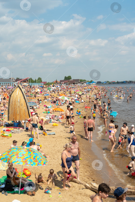 Скачать Многолюдный пляж из-за закрытых границ. Коронавирус и закрытые пляжи. Россия, Татарстан, 20 июня 2021 года. Вертикальное фото. фотосток Ozero