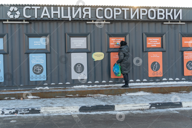Скачать Женщина складывает пластик в контейнер с мусором. Вид сзади. Россия, Татарстан, 04 декабря 2020 года фотосток Ozero