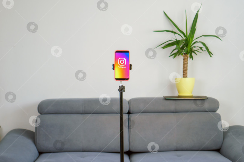 Скачать Крупный план телефона с надписью tiktok на штативе в домашней комнате. Рабочее место блогера, без людей. фотосток Ozero