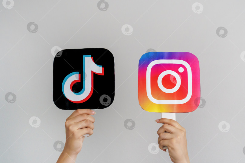 Скачать Девочки-подростки держат в руках логотипы TikTok и Instagram на сером фоне. Концепция использования подростками самых популярных социальных сетей. Турция, Стамбул, 17 сентября 2024 года. фотосток Ozero