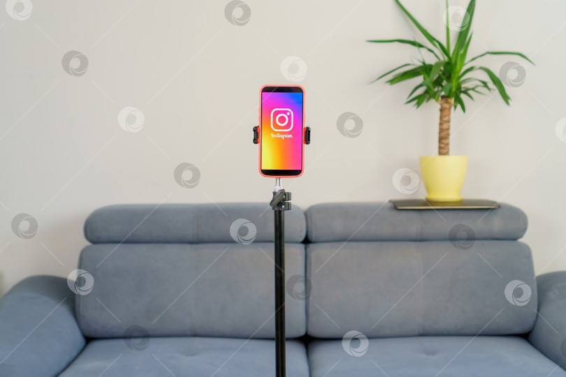 Скачать Телефон с надписью Instagram на штативе в домашней комнате. Рабочее место блогера, без людей. Турция, Стамбул, 17 сентября 2024 года. фотосток Ozero