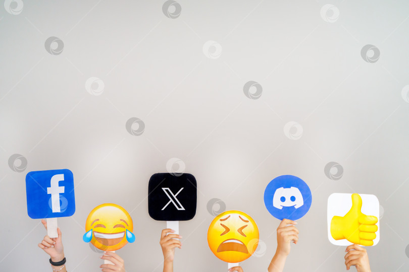 Скачать Девушки держат в руках значки с логотипами Discord, Facebook, Twitter и различными эмодзи. Турция, Стамбул, 17 сентября 2024 года. фотосток Ozero