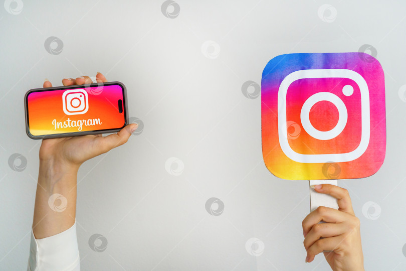 Скачать Девушка держит в руках телефон с логотипом Instagram и надписью Instagram. Турция, Стамбул, 17 сентября 2024 года. фотосток Ozero