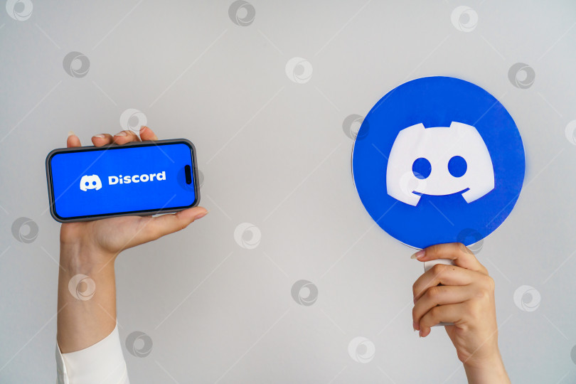 Скачать Девушка держит в руках телефон с логотипом discord и надписью Discord. Турция, Стамбул, 17 сентября 2024 года. фотосток Ozero