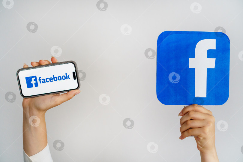 Скачать Девушка держит в руках телефон с логотипом Facebook и надписью Facebook. Турция, Стамбул, 17 сентября 2024 года. фотосток Ozero