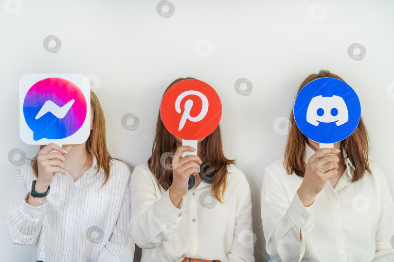 Скачать группа подростков с логотипами Facebook messenger, Pinterest, Discord на сером фоне. Концепция использования подростками самых популярных социальных сетей. Турция, Стамбул, 17 сентября 2024 года. фотосток Ozero