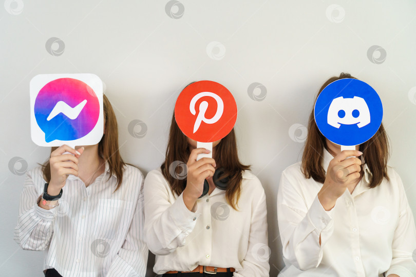 Скачать Девушки держат в руках значки с логотипами Discord, Facebook, Pinterest.  Турция, Стамбул, 17 сентября 2024 года. фотосток Ozero