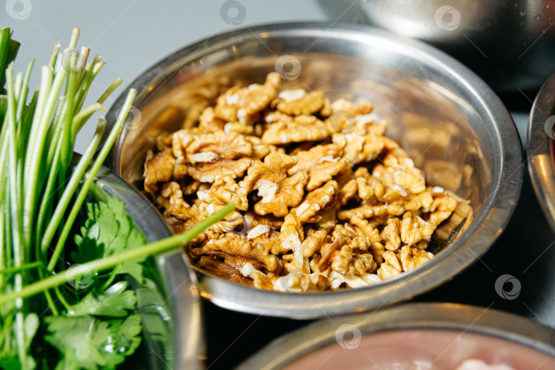 Скачать Миска с очищенными от скорлупы грецкими орехами, подготовленными к приготовлению. фотосток Ozero