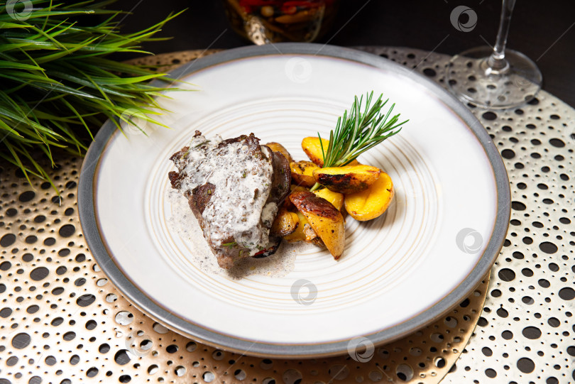 Скачать Говяжий стейк со сливочным соусом и жареным картофелем. фотосток Ozero