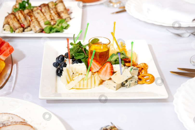 Скачать Сырное ассорти с медом, фруктами и крендельками. фотосток Ozero