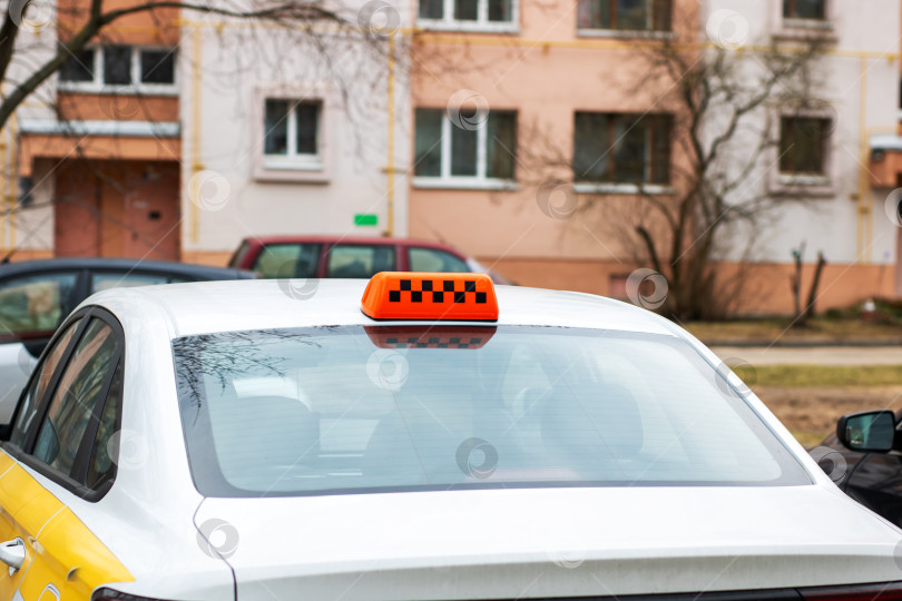 Скачать На белом автомобиле такси отчетливо видна оранжевая вывеска фотосток Ozero