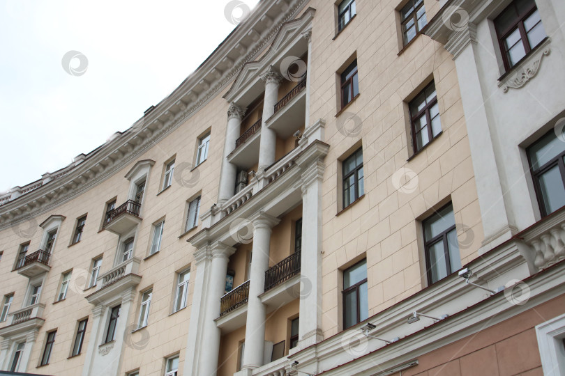Скачать Я смотрю на высокое здание, украшенное балконами и окнами фотосток Ozero
