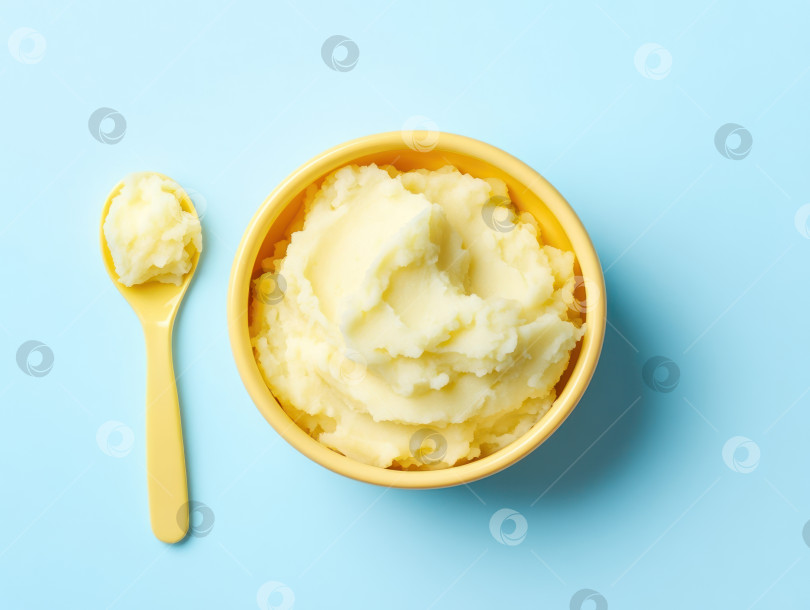 Скачать Ярко-желтая детская миска со сливочным картофельным пюре на нежно-голубом фоне фотосток Ozero