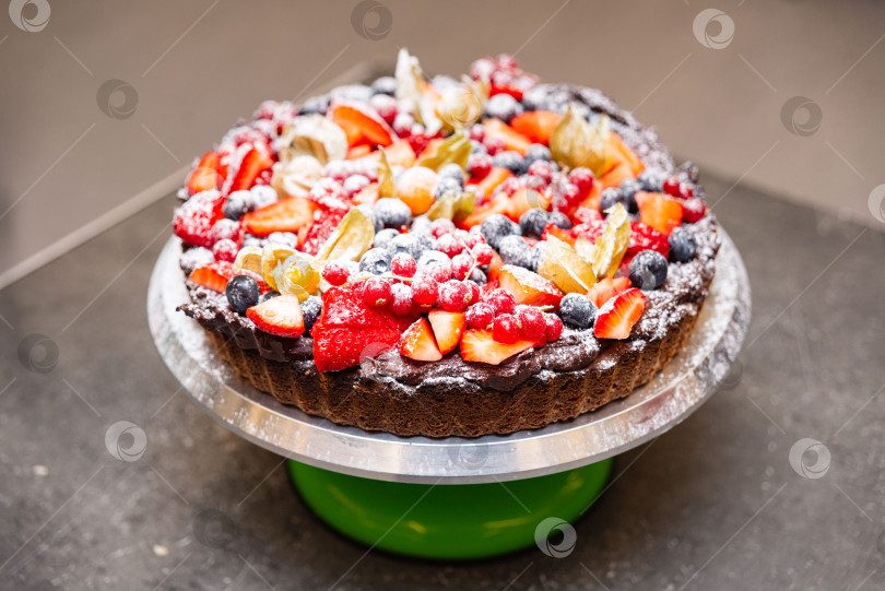 Скачать Шоколадный пирог, посыпанный свежими ягодами и сахаром. фотосток Ozero