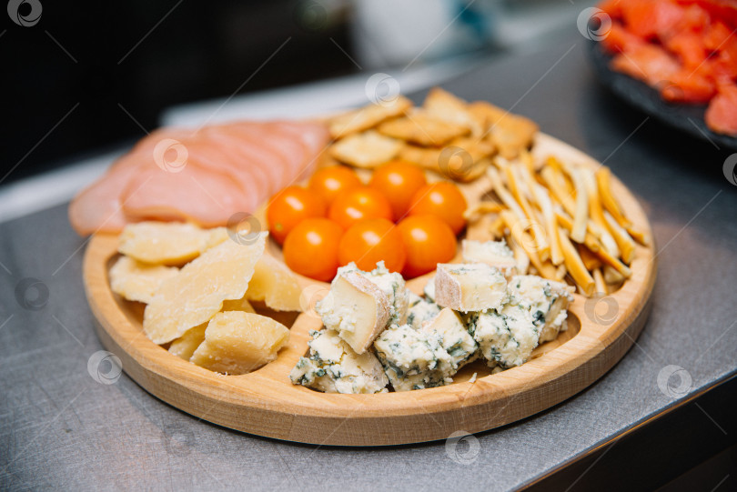 Скачать Ассорти из сыра и мясной нарезки на доске с закусками. фотосток Ozero