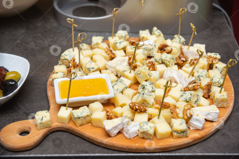 Скачать Сырное ассорти с медом и орехами на тарелке. фотосток Ozero