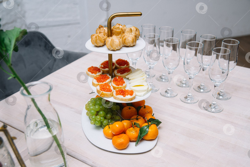Скачать Элегантная многоярусная закусочная с фруктами и закусками. фотосток Ozero