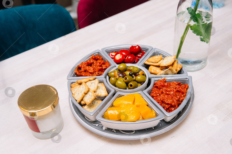 Скачать Красочный поднос для закусок с соусами, оливками и крекерами. фотосток Ozero