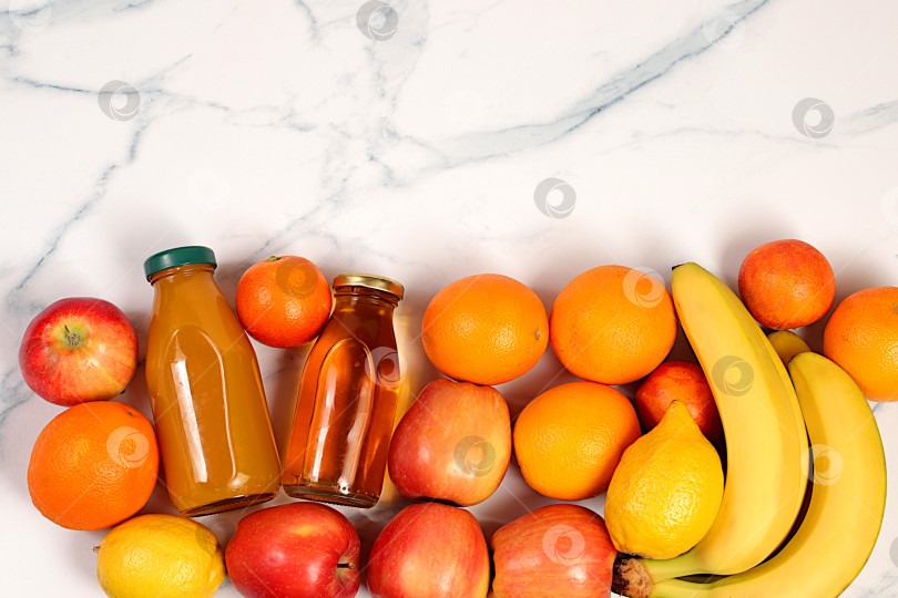 Скачать Полезные веганские продукты для здорового образа жизни. Яблоки, апельсины, лимоны, мандарины, бананы и натуральные соки на бетонном фоне, концепция детокс-диеты и похудения, реклама магазина фотосток Ozero