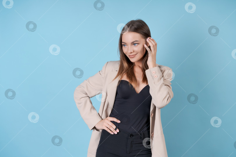 Скачать Счастливая деловая женщина, стоящая и улыбающаяся изолированно на синем фоне студии. фотосток Ozero