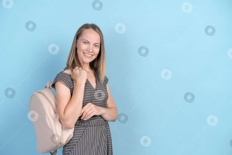 Скачать Интерьерная фотография симпатичной женщины средних лет, изолированной на синем фоне, одетой фотосток Ozero