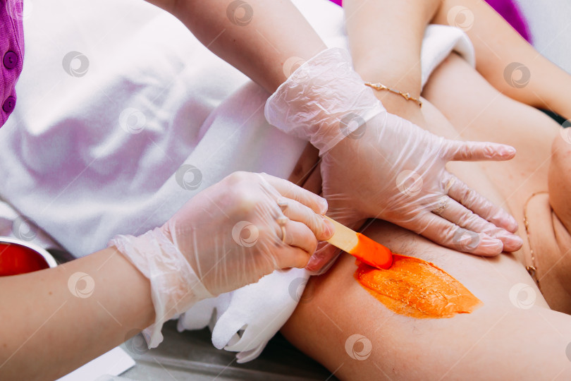 Скачать Крупным планом женщина делает эпиляцию подмышек воском у косметолога в салоне красоты фотосток Ozero