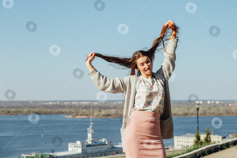 Скачать Портрет улыбающейся женщины в белом кардигане. Смеющаяся девушка на фоне улицы, свободы и счастья фотосток Ozero
