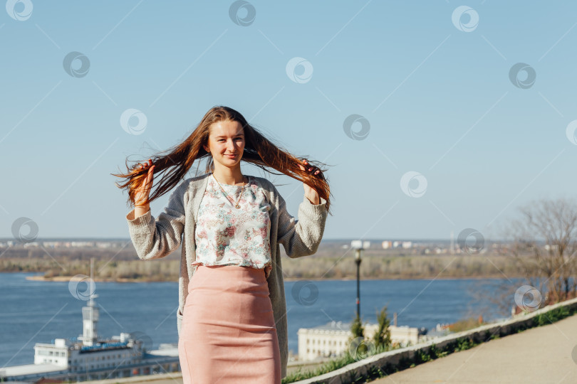 Скачать Портрет улыбающейся женщины в белом кардигане. Смеющаяся девушка на фоне улицы, свободы и счастья фотосток Ozero