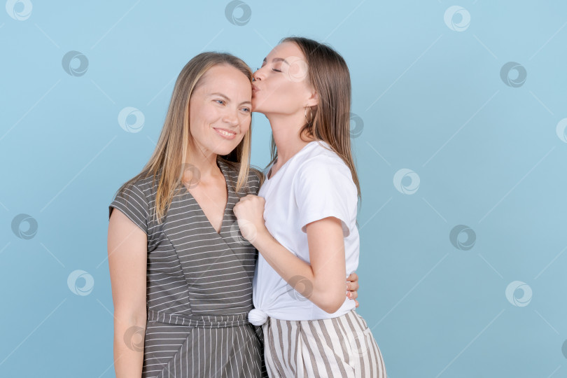 Скачать Концепция единства. Дочь-кавказка обнимает свою маму, демонстрируя свою любовь в повседневной фотосток Ozero