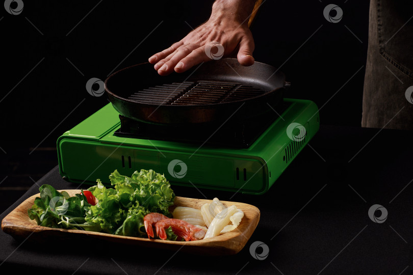 Скачать Шеф-повар готовит морепродукты, креветки на сковороде с овощами. фотосток Ozero